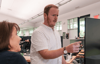 CRM administrator points at a computer screen