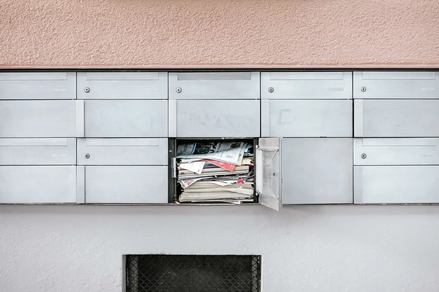 Newspapers overflowing out of a PO box
